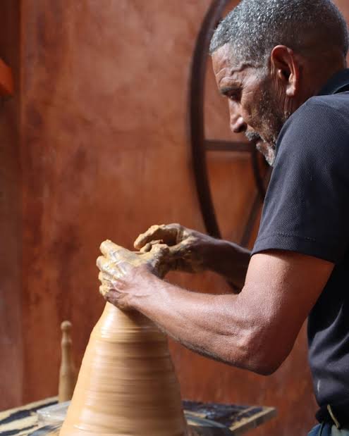 Artesano trabajando una pieza de barro durante el proceso de elaboración de cerámica artesanal.