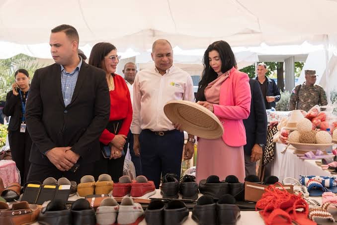 Visitantes recorriendo una feria artesanal con puestos de productos hechos a mano en República Dominicana.
